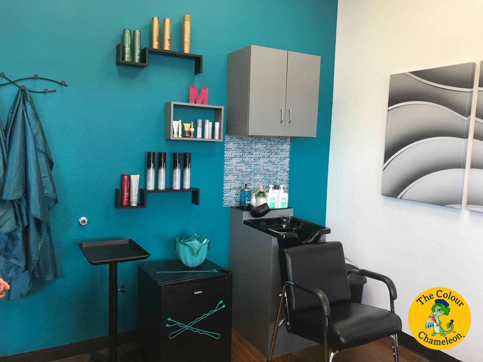 The same salon suite with a deep teal accent wall, gray cabinetry and a mosaic tile backsplash