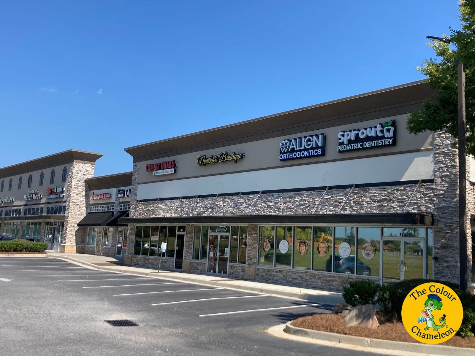 The same shopping center with the band repainted soft warm white and the trim in dark charcoal