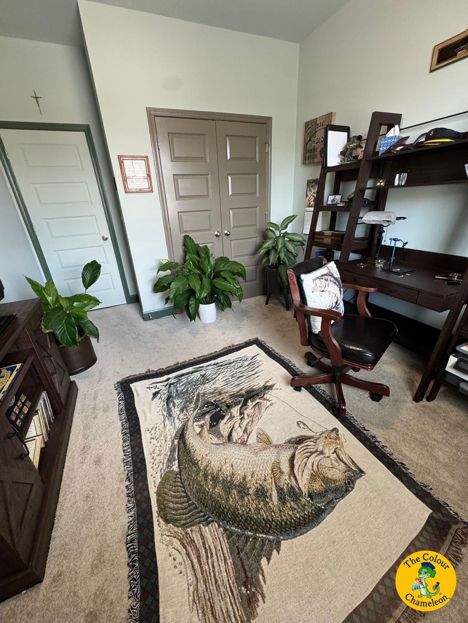 The same room painted soft sage green with mushroom-taupe closet doors and deeper green door casings, furnished as a study