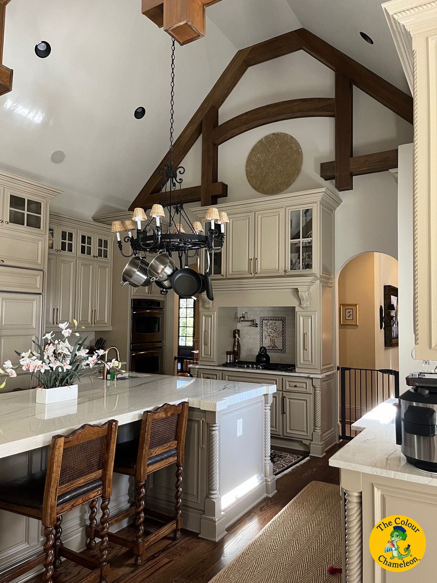 The same kitchen with the cabinetry painted a soft greige, the beams and layout unchanged