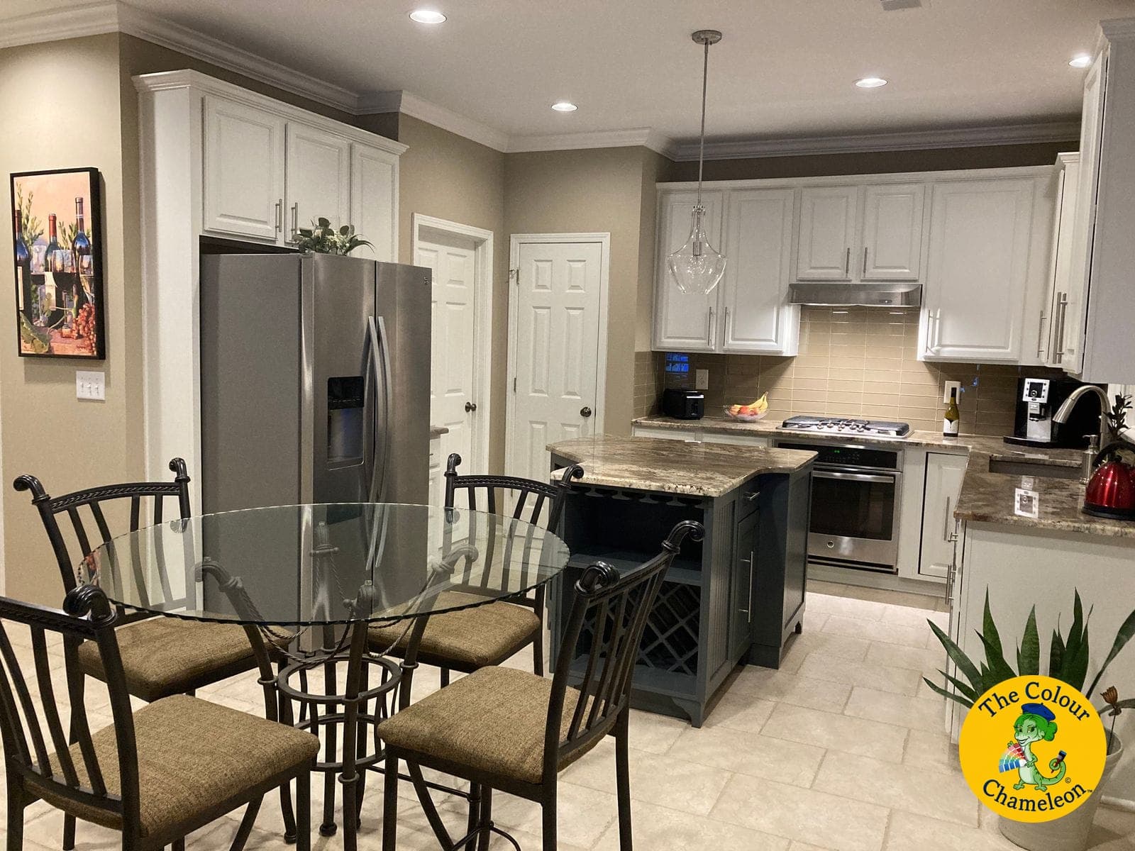 The same kitchen with the cabinets painted white, warm greige walls and a deep slate blue island